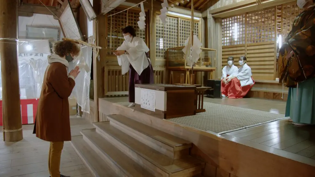 Beten in einem japanischen Schrein vor der Opferbox.